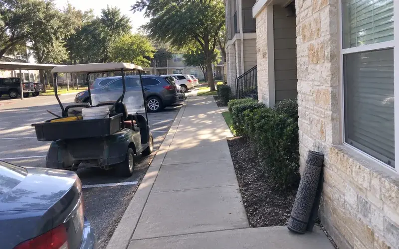 Apartment complex exterior in a suburban Tarrant County setting with parked cars
