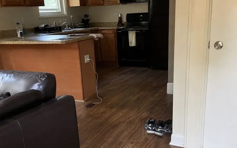 Apartment kitchen with laminate countertops and black appliances in overcast light