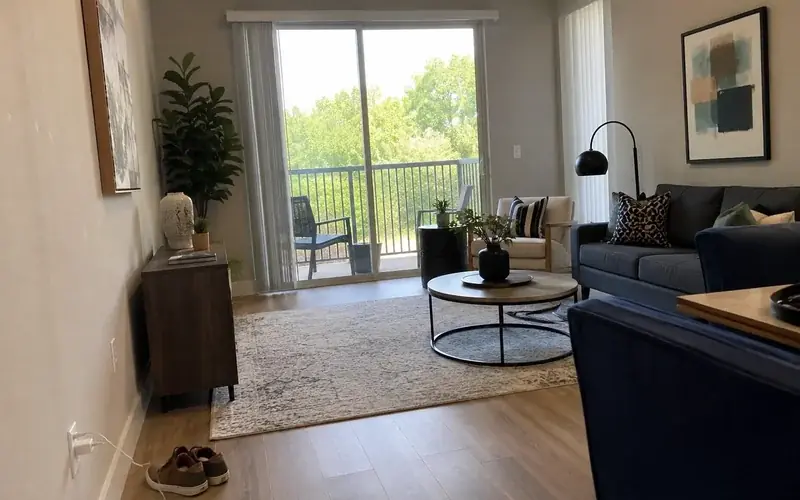 Apartment living room interior with vinyl plank flooring and a sliding balcony door