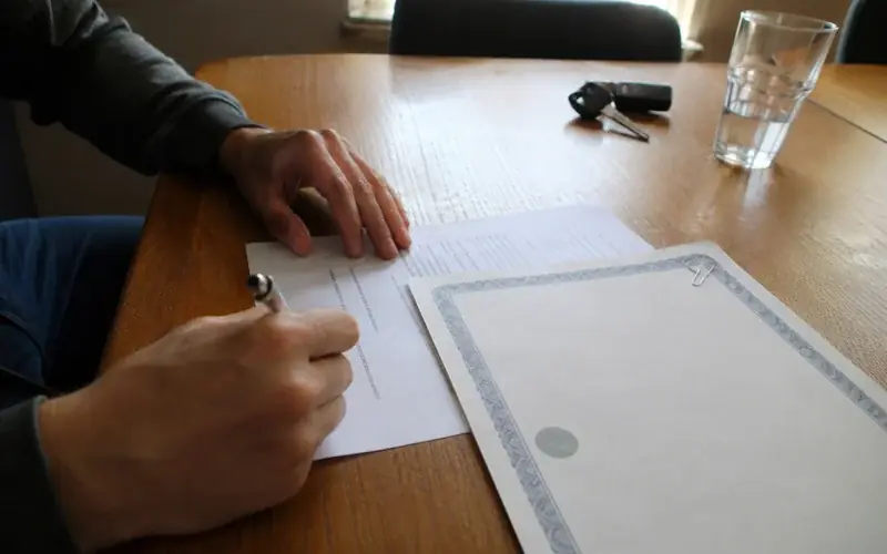 Employment letter and a program completion certificate paperclipped together on a desk