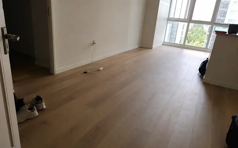 Empty new apartment interior with vinyl plank flooring and large windows in flat daylight