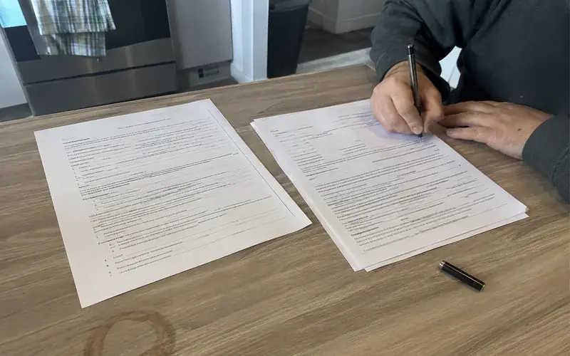 Lease paperwork and a guarantee program agreement side by side on a kitchen table