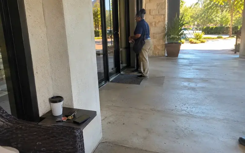 Leasing office entrance with glass doors and a covered walkway, no people present