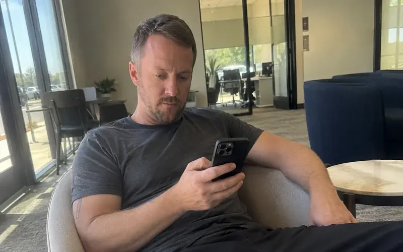 Person seated in a leasing office waiting area, casual clothing, unposed