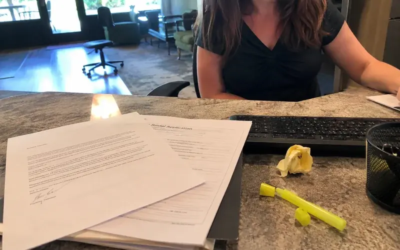 Rental application packet with a cover letter on top resting on a leasing office counter