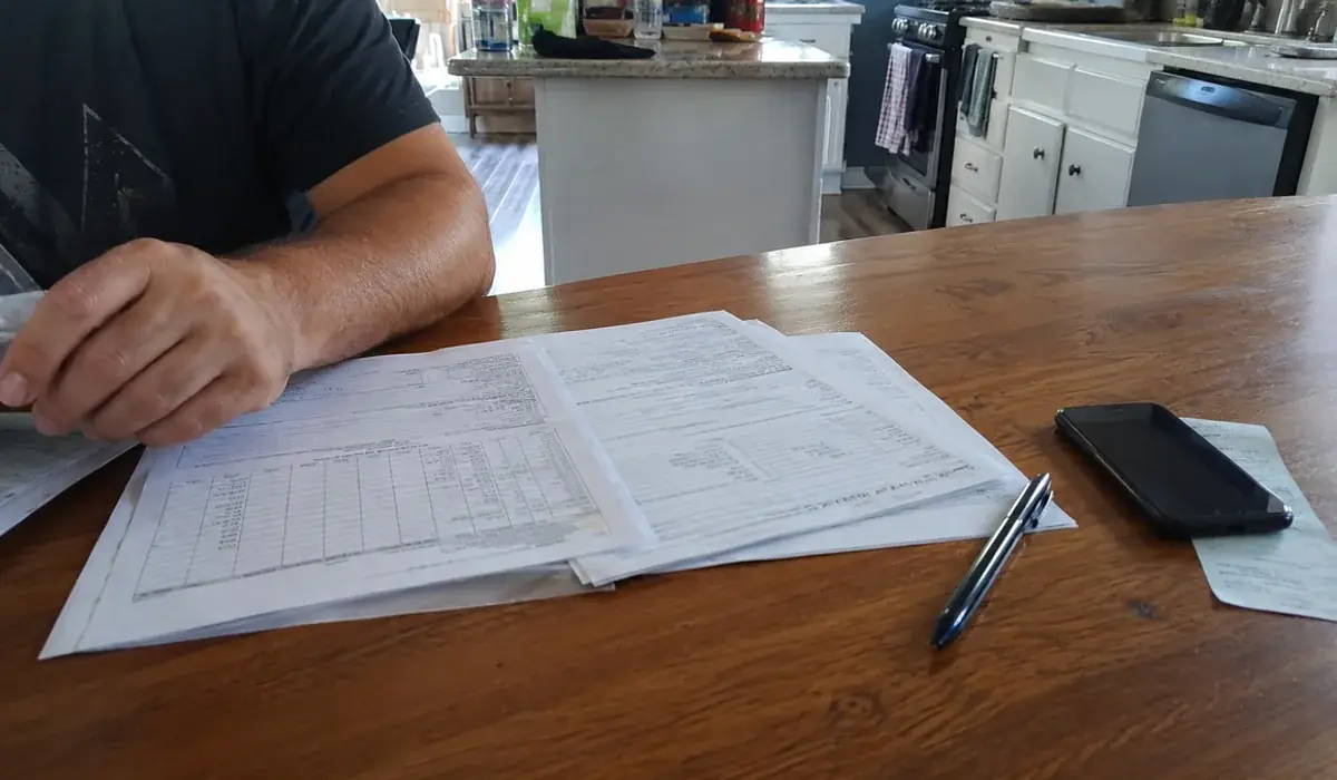 Income certification paperwork for a Fort Worth tax-credit apartment beside a household size worksheet