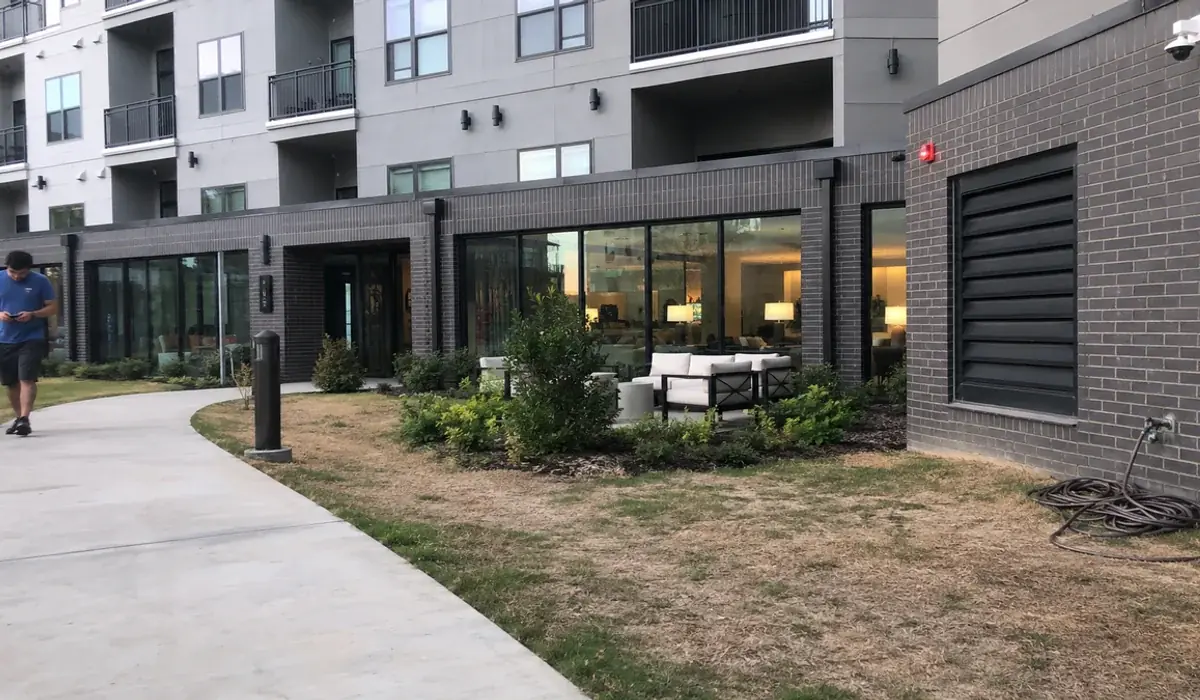 Newer four-story apartment building with balconies and a ground-floor leasing office