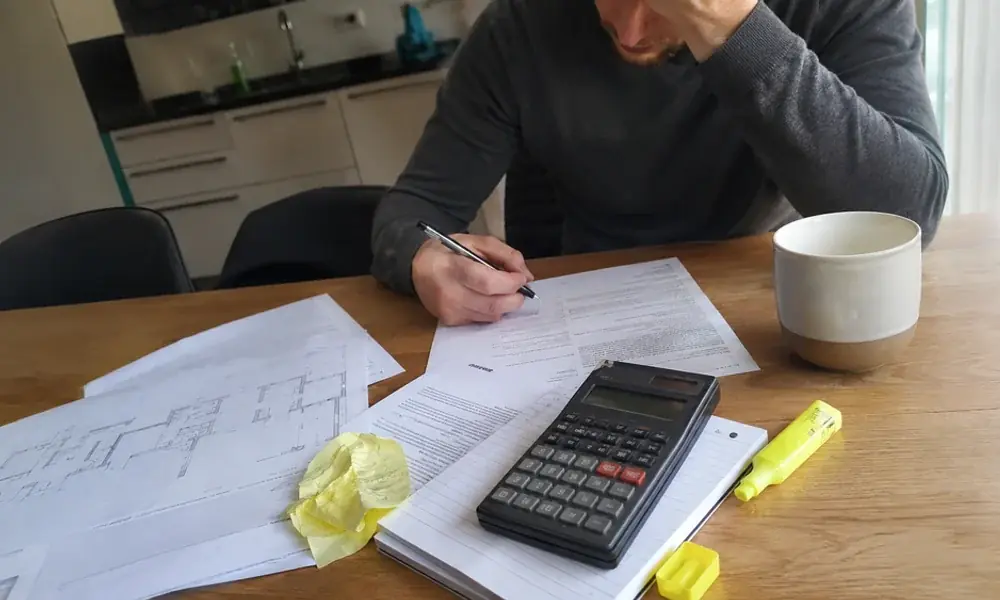 Printed lease pages, a calculator, and a settlement letter on a kitchen table