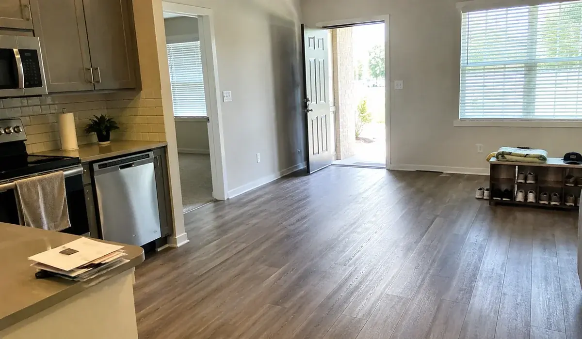 Empty apartment living room with clean vinyl plank flooring, ready to move into